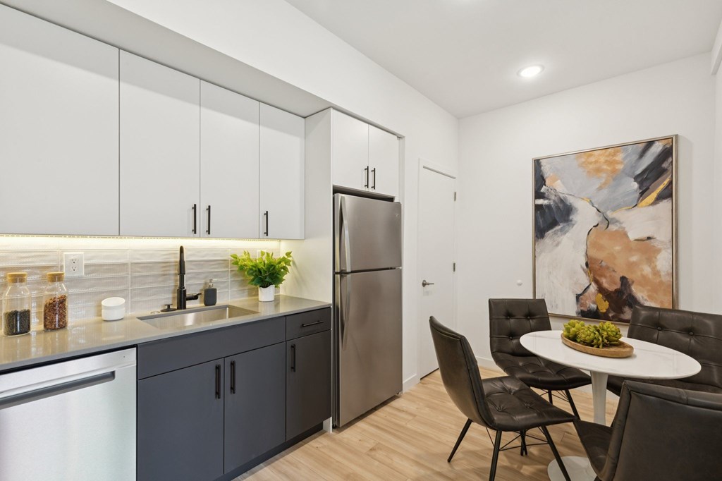 A modern kitchen with a dining table set for two.