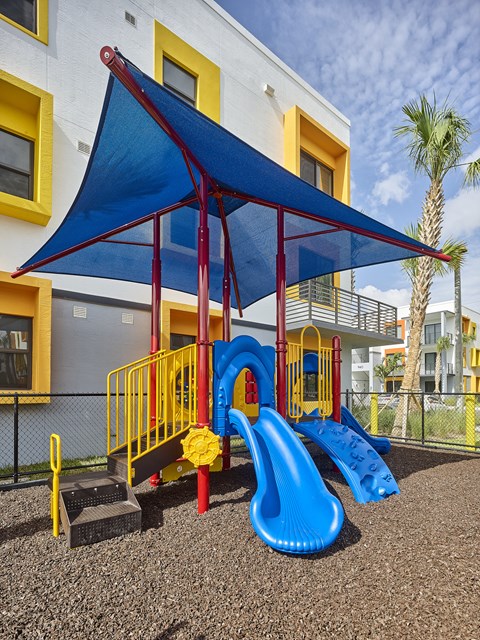 Outdoor playground at Gateway Luxury Apartments in Pompano Beach, featuring safe, modern play structures for children in a landscaped setting.