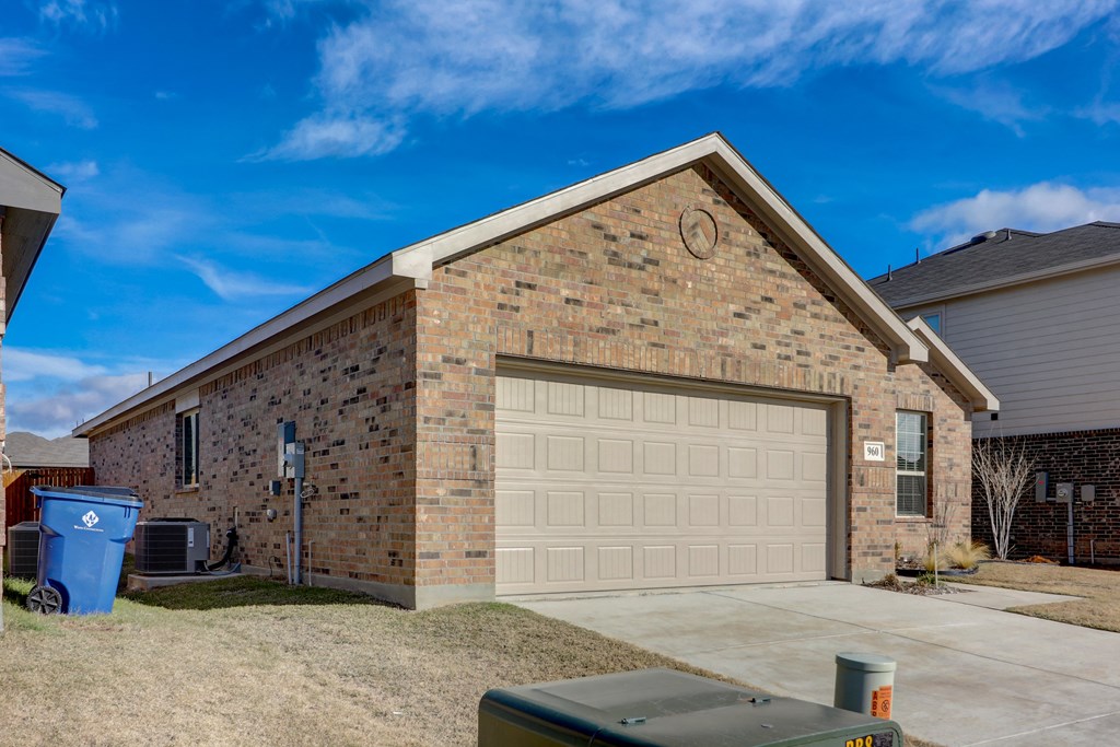 a brick house with a garage and a driveway