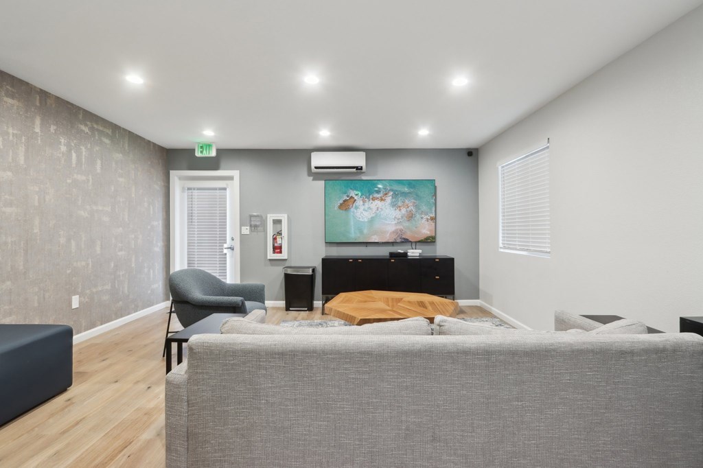 A bedroom with a bed, chair, and painting on the wall.