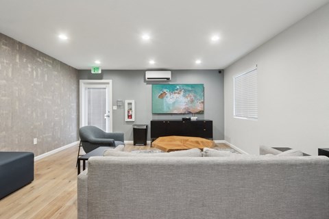 A bedroom with a bed, chair, and painting on the wall.