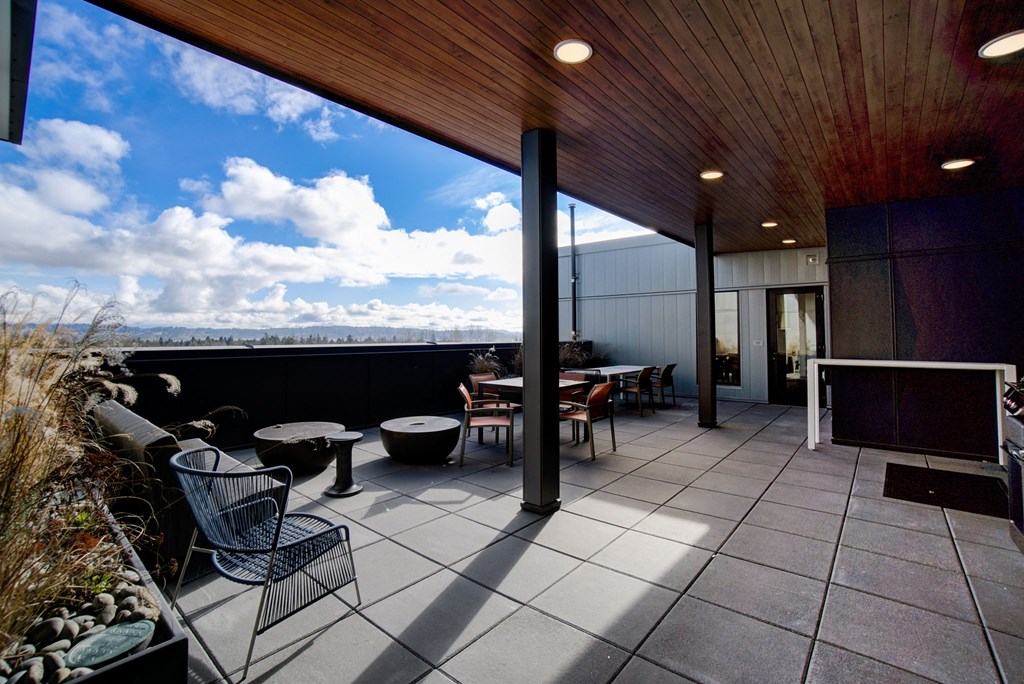 a terrace with tables and chairs and a view of the sky
