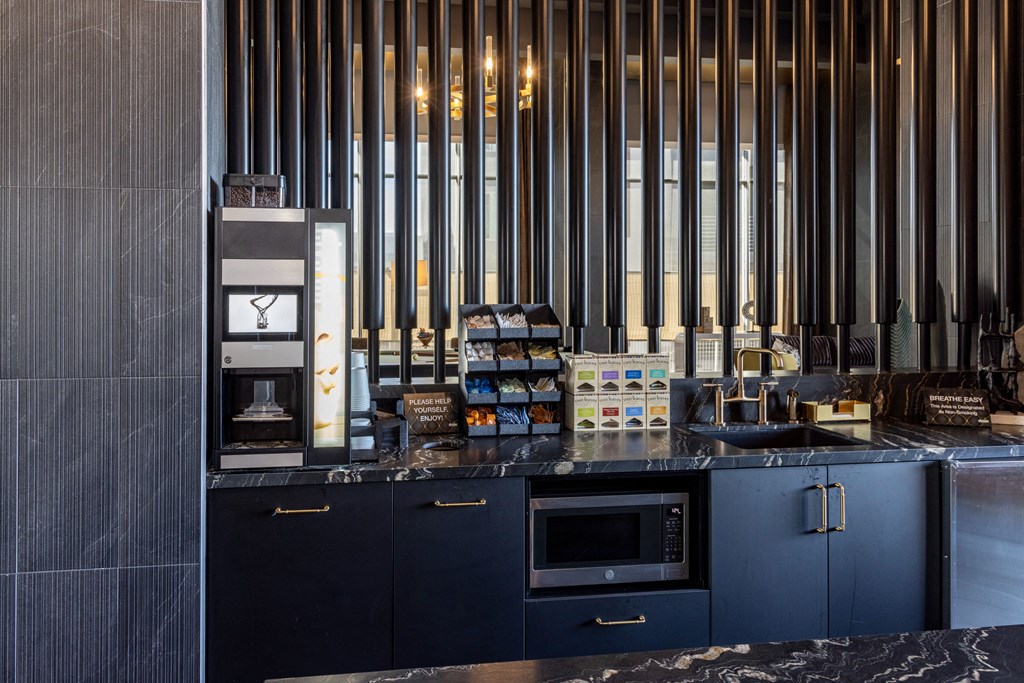 a kitchen with blue cabinets and a counter top with a stove and a microwave