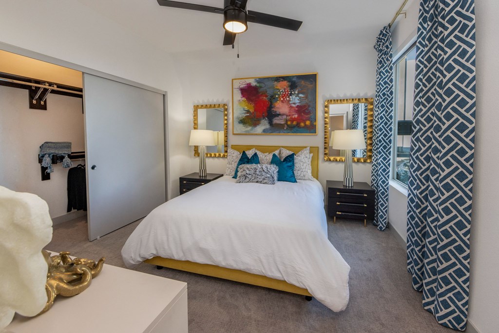 a bedroom with a white bed and blue and white curtains