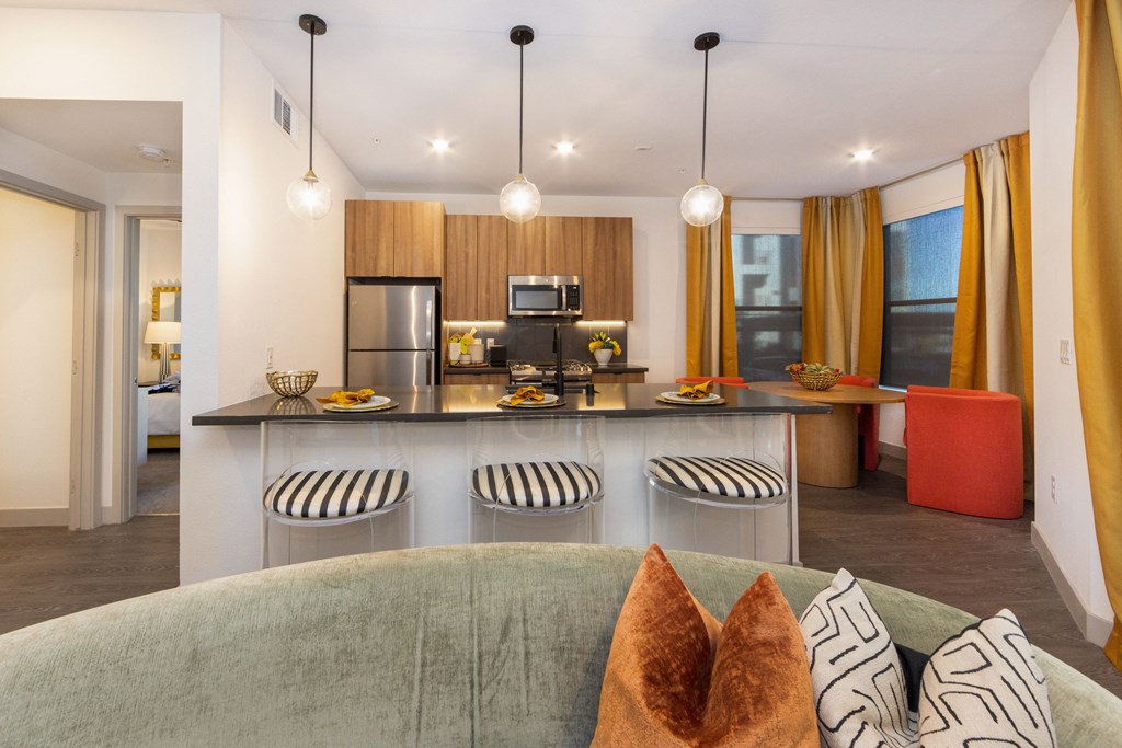 a living room with a couch and a kitchen with a table and chairs