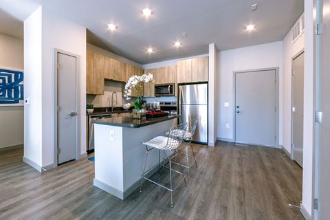 a kitchen with a island and a stainless steel refrigerator