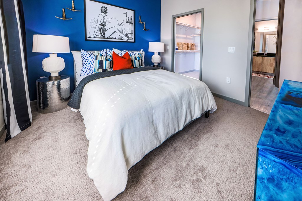 a blue and white bedroom with a bed and blue walls