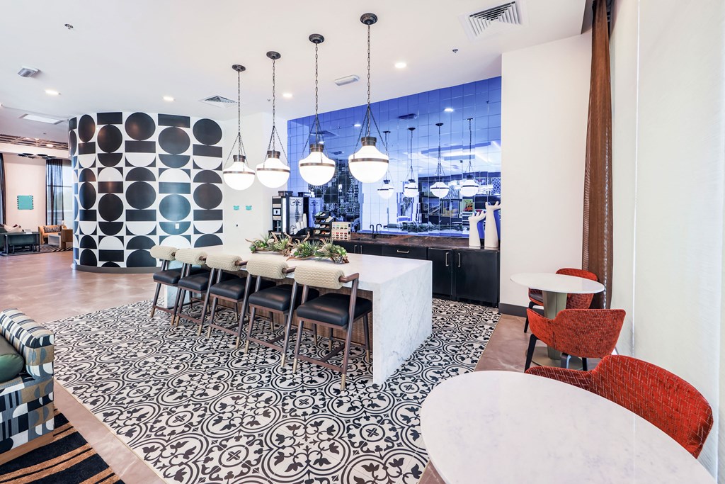 a dining area with a table and chairs and a kitchen in the background