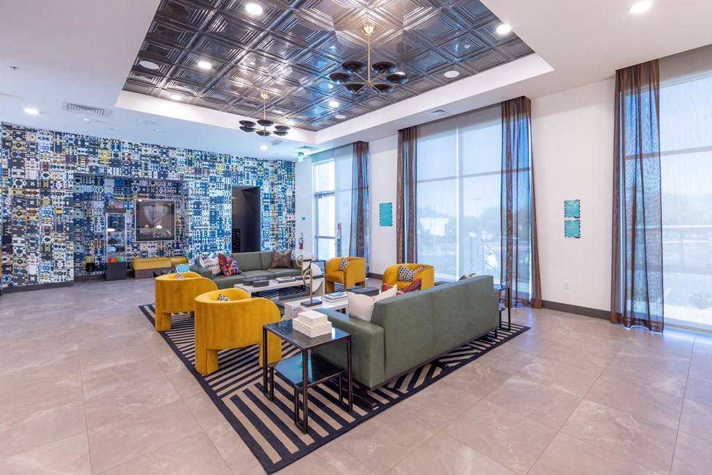 a living room with couches and chairs and a wall of mosaic tiles