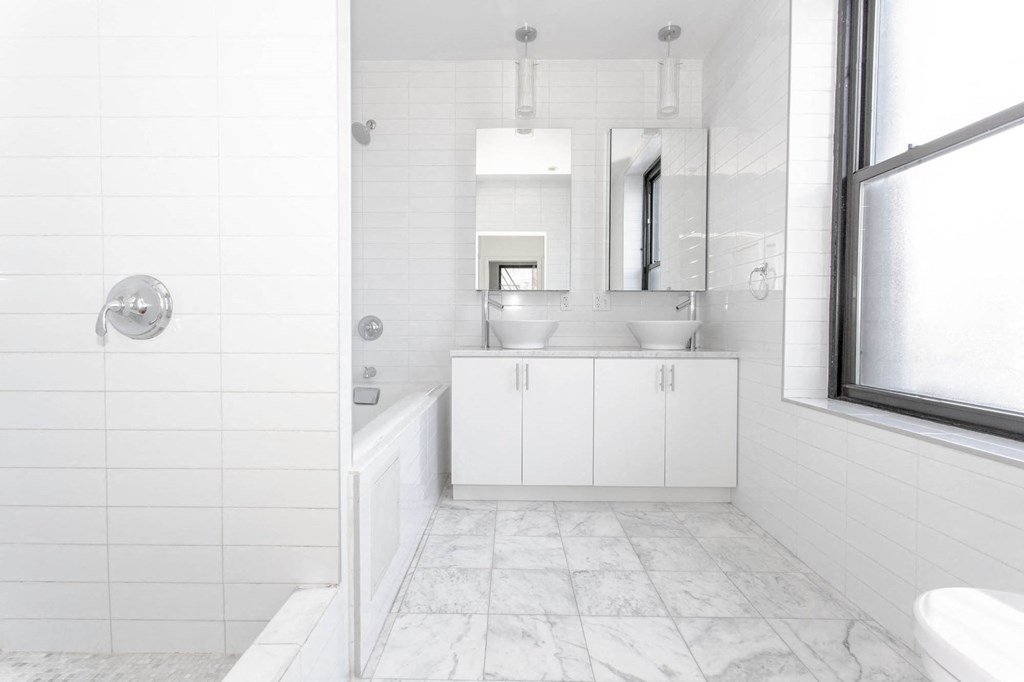 a white bathroom with a tub and a sink