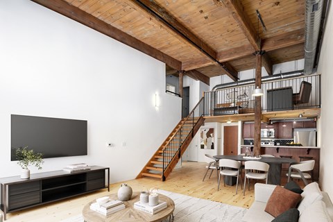 a living room with a staircase and a tv in a loft