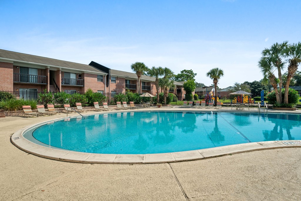 Outdoor resort-style pool area with lounge chairs at Townsend Apartments in Jacksonville near Atlantic Beach, Florida.