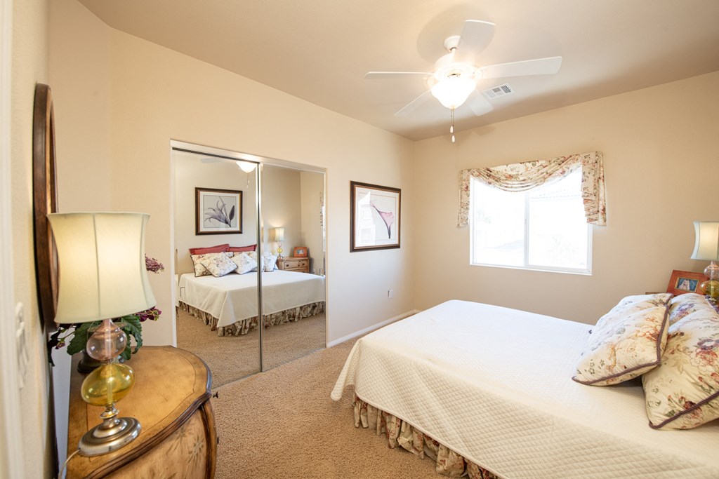 a bedroom with a large bed and a ceiling fan