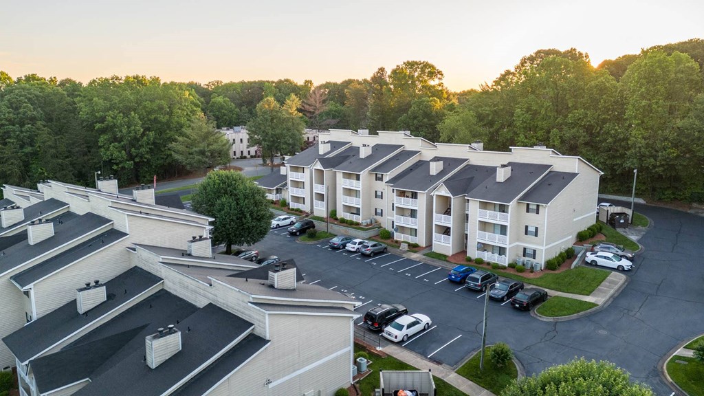an aerial view of an apartment complex with cars parked in a parking lot