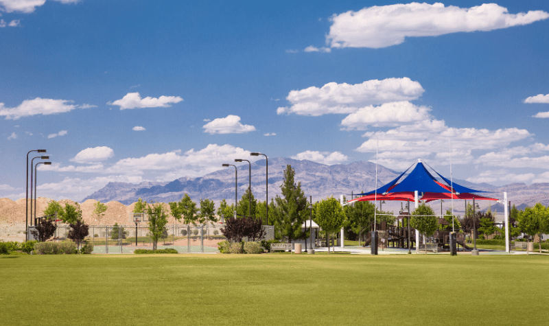 a park with a playground and mountains in the background