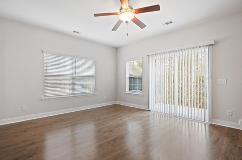 Harris Trail Luxury Townhomes for rent Richmond Hill, GA photo of an empty living room with a ceiling fan and a window