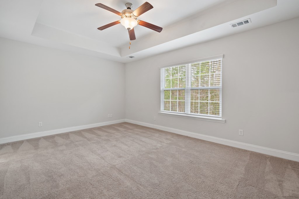 Harris Trail Luxury Townhomes for rent Richmond Hill, GA photo of an empty living room with a ceiling fan and a window
