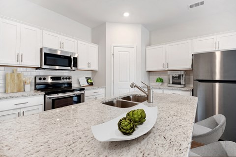 a large kitchen with stainless steel appliances and granite counter tops