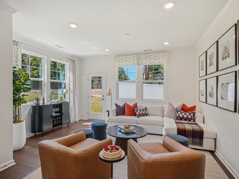 A living room with brown leather chairs and a white couch.