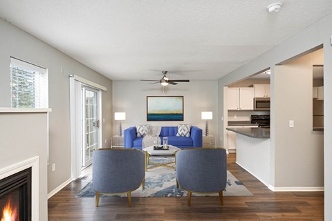 A living room with a fireplace and two blue chairs.