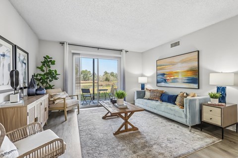 A living room with a couch, chair, and a painting on the wall.