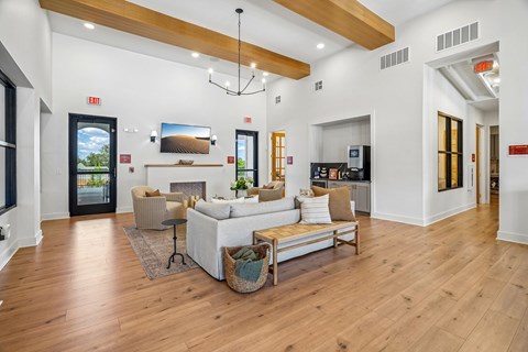 A living room with a white couch and a wooden floor.