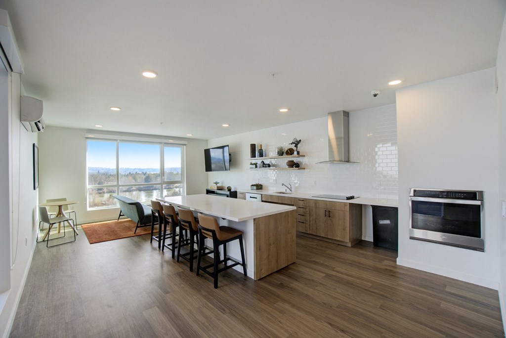 a kitchen and dining room with a white counter top and wooden floors