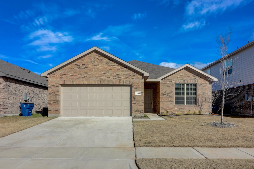 a brick house with a garage and a blue sky