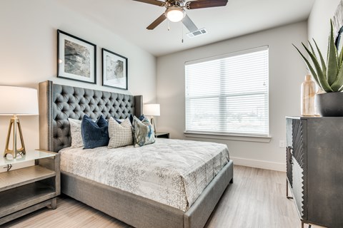A bedroom with a large bed and a ceiling fan.