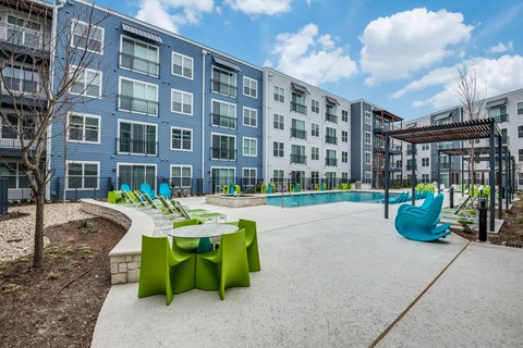 A playground area with a slide and a table surrounded by apartment buildings.