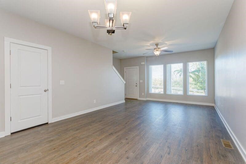 an empty living room with a ceiling fan and a window