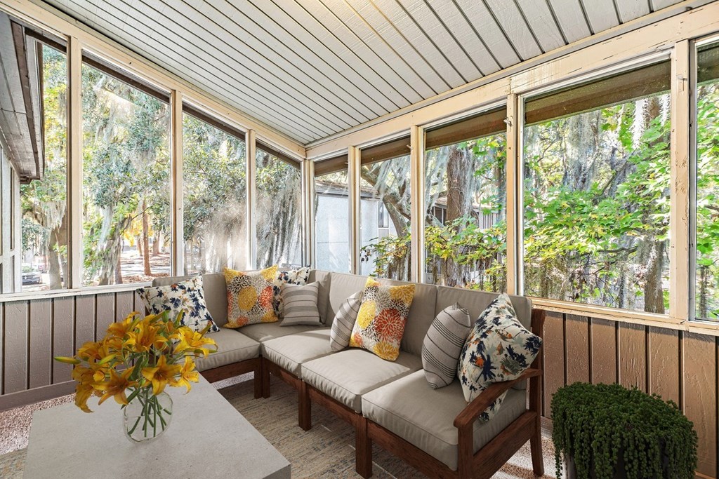 Greentree Apartments in Savannah, GA photo of a screened porch with a couch and a table with flowers