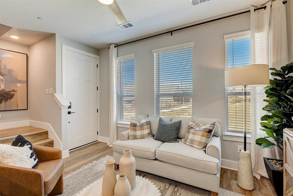 a living room with a couch and three windows