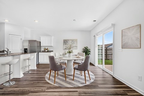 A modern kitchen with a dining table and chairs.
