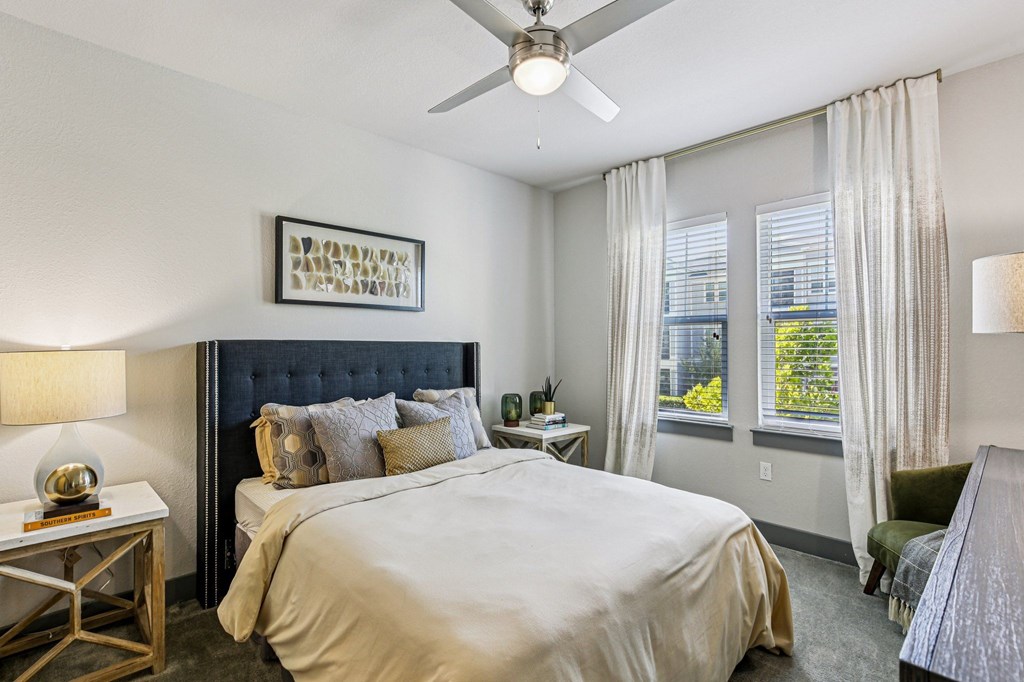 Spacious bedroom with large windows and ceiling fan at Lotus at Starkey Ranch in Odessa, Florida.