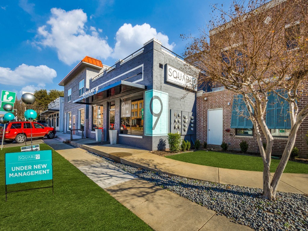 a blue building with a tree in front of it