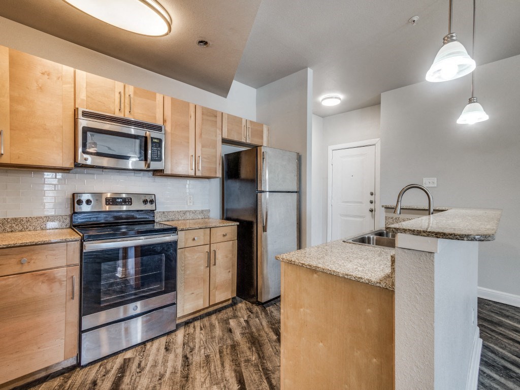 a kitchen with wooden cabinets and stainless steel appliances