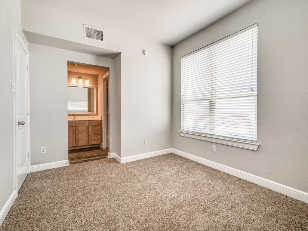 a bedroom with a large window and carpet