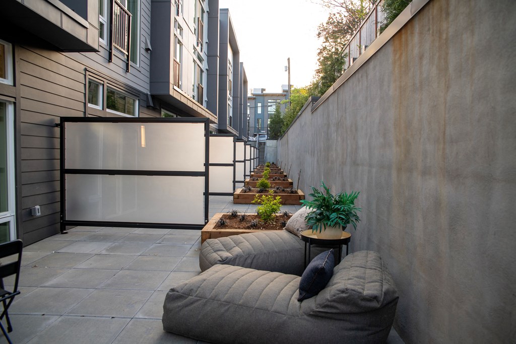 a patio with a couch and a table next to a wall