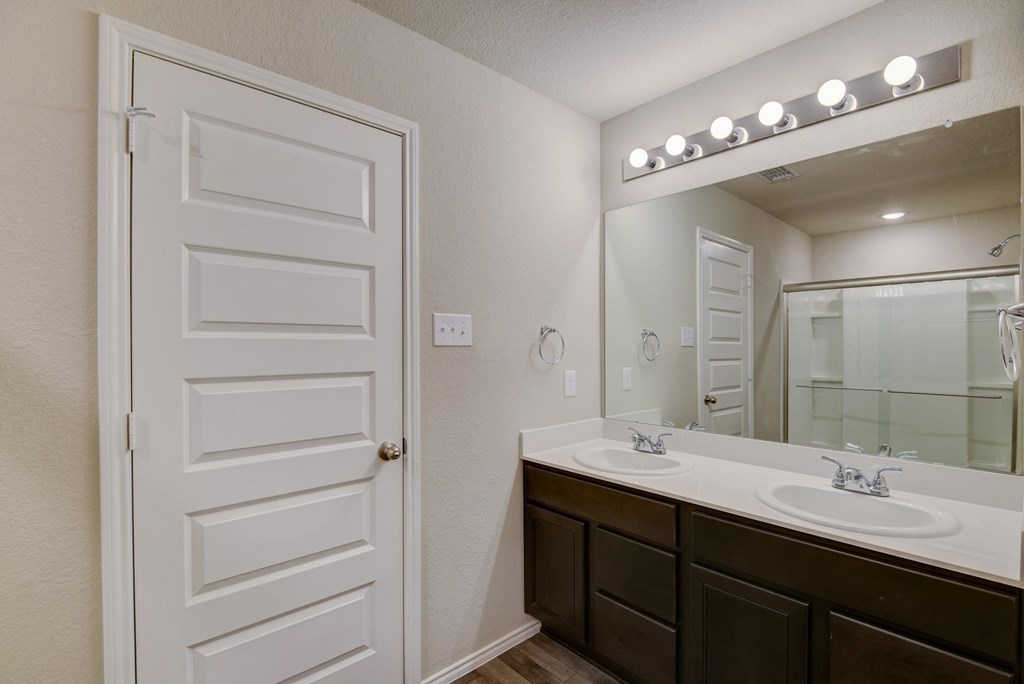 an empty bathroom with a large mirror and two sinks