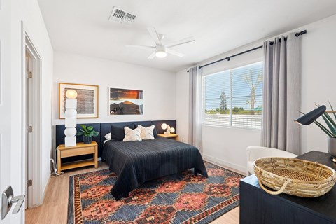 A bedroom with a large bed and a ceiling fan.