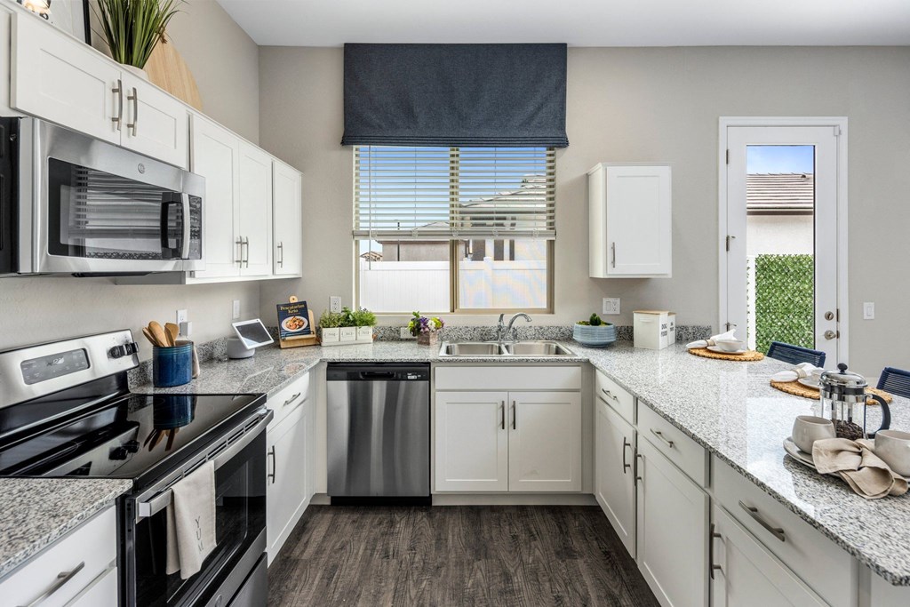 A kitchen with white cabinets and a black stove top.