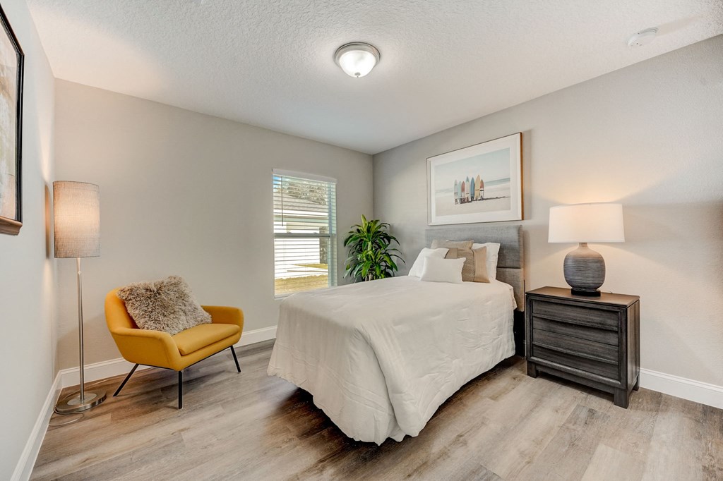 Guest bedroom with hardwood floors at The Groves at Lake Ella in Lady Lake, Florida, a pet-friendly rental community.