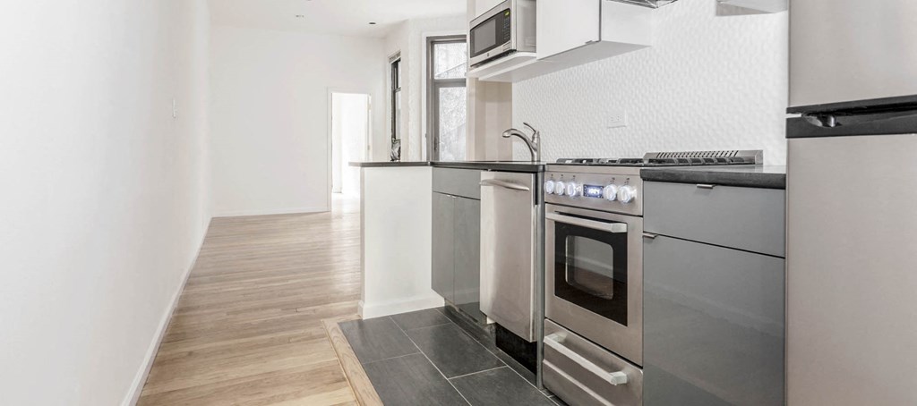 a kitchen with stainless steel appliances and a wooden floor