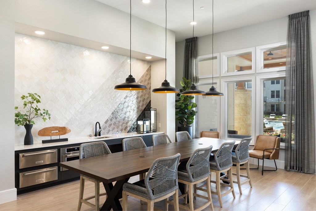 a kitchen with a long wooden table and chairs in front of a large window