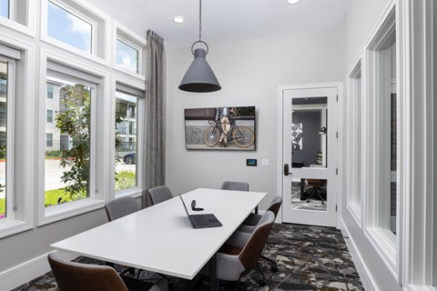 a conference room with a white table and chairs and large windows