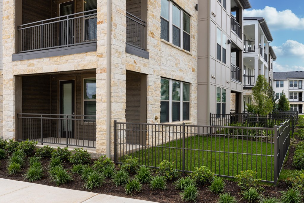 an exterior view of a building with green grass and a fence
