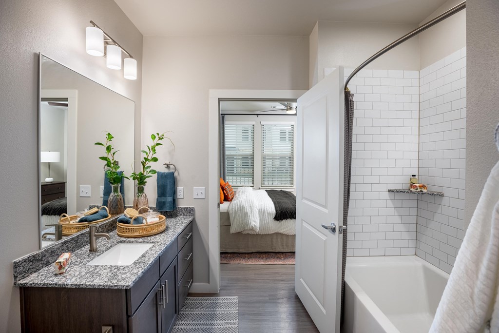 an open bathroom with a shower and a tub and a bedroom