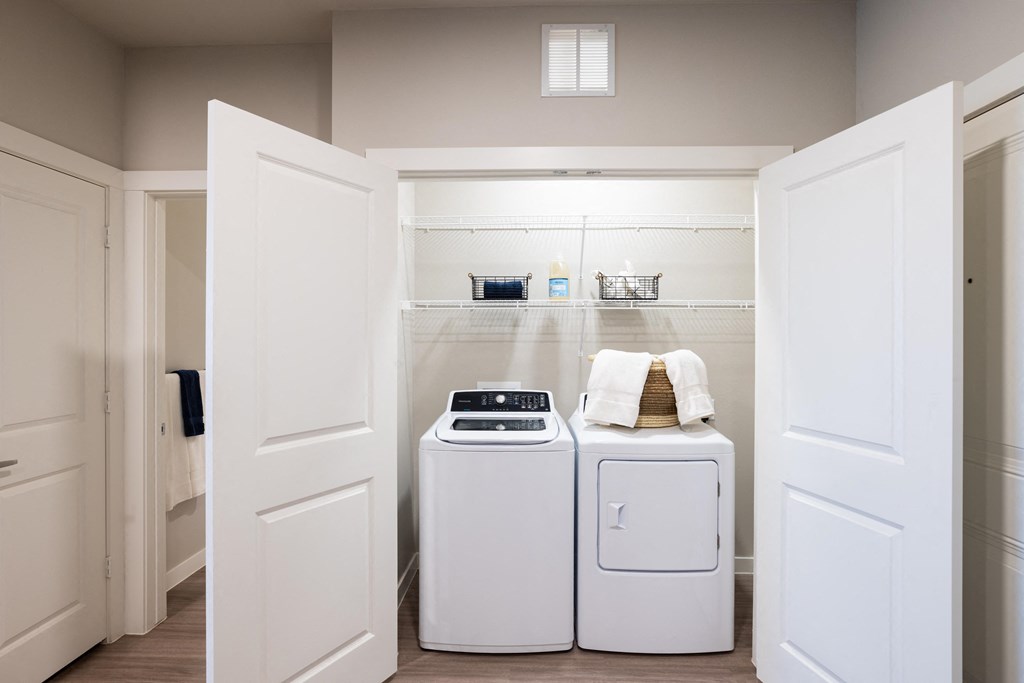 a washer and dryer in a laundry room with white cabinets