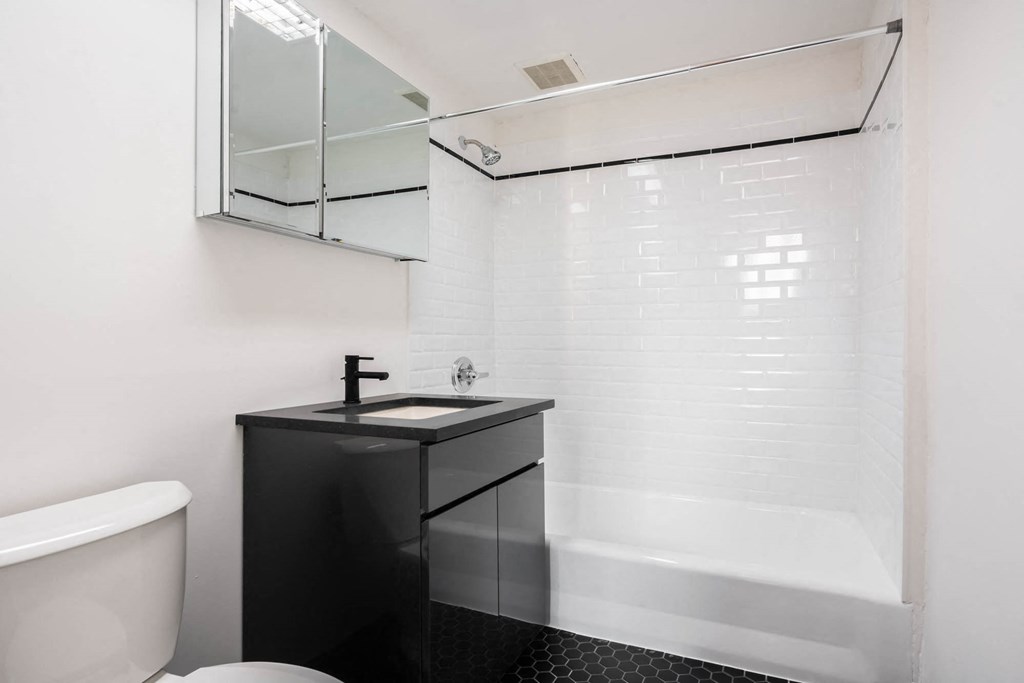 a white bathroom with a sink and a bath tub